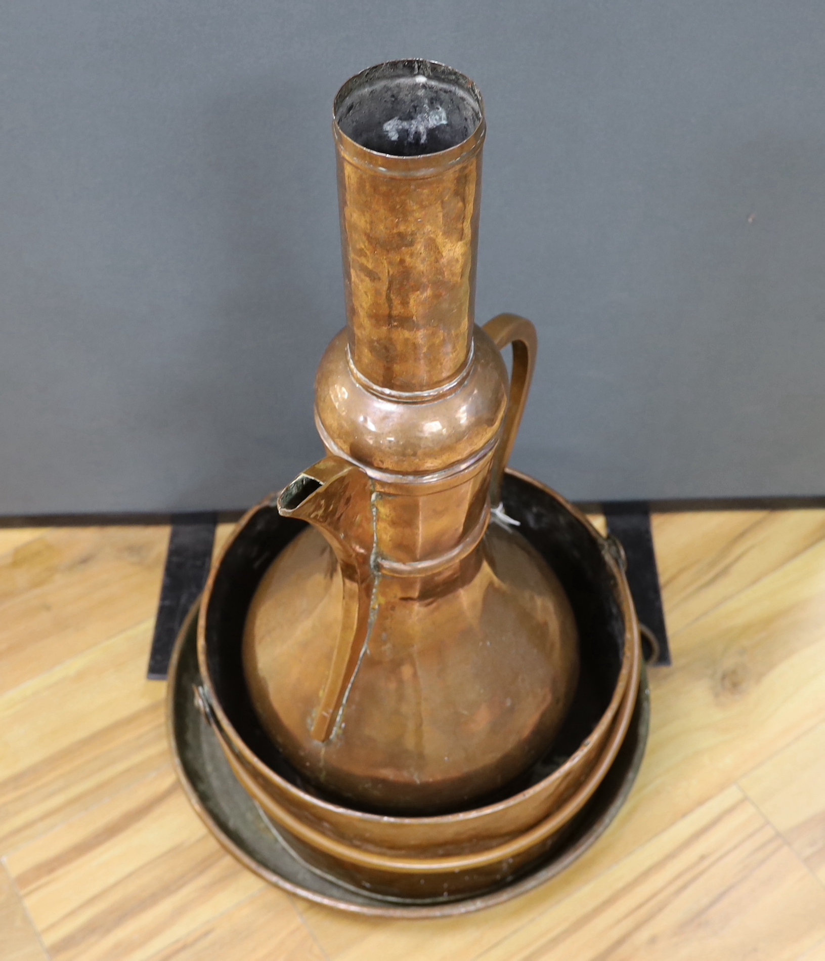 A shallow copper dish a copper cooking pot and a large, Middle Eastern coffee pot,-77cm high